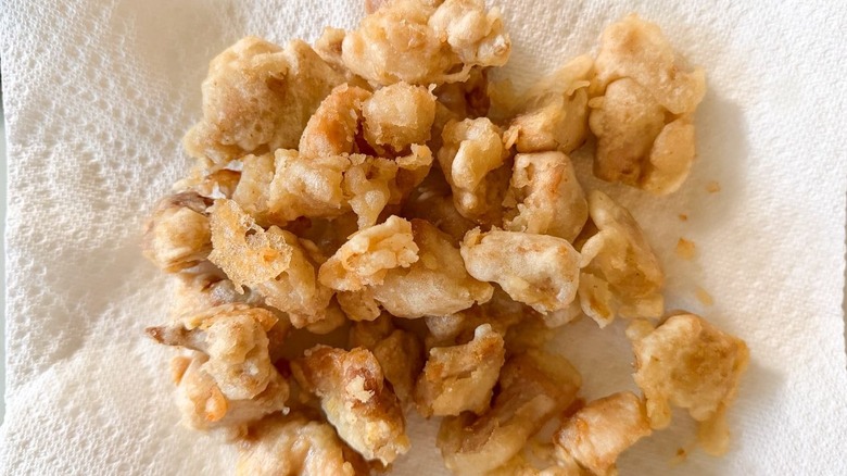 Battered and fried chicken thigh pieces on paper towels
