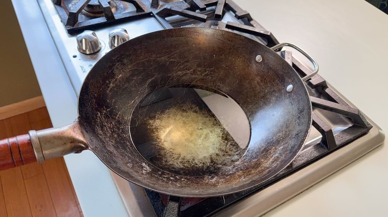 Peanut oil heating in a wok on stovetop