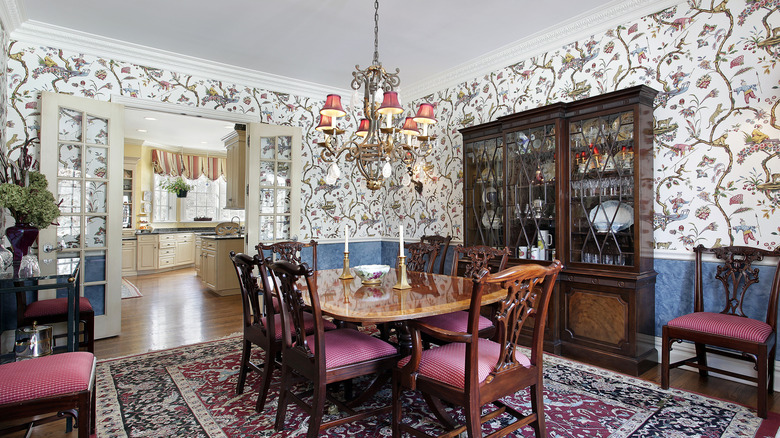Dining room with floral wallpaper and a large wooden table with chairs
