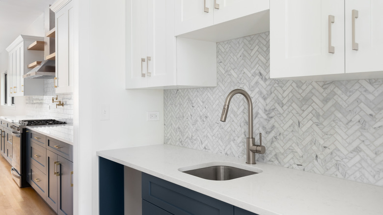 Kitchen with herringbone pattern tile as backsplash behind sink