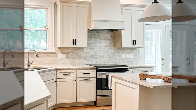 A Nancy Meyers-inspired remodeled kitchen with off-white cabinetry and a large kitchen island