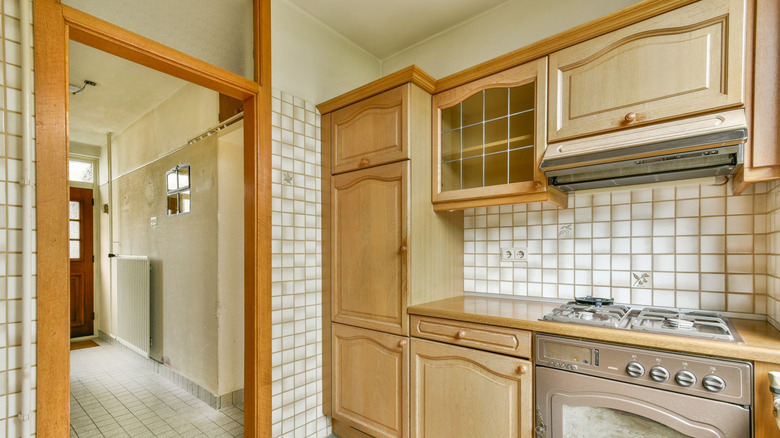 Vintage kitchen with warm wood cabinets and beige tile backsplash