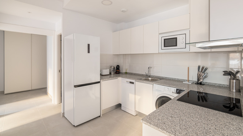 Mostly white kitchen with white appliances and a granite countertop