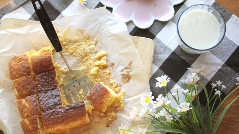 plate of cornbread next to a glass of milk on a table