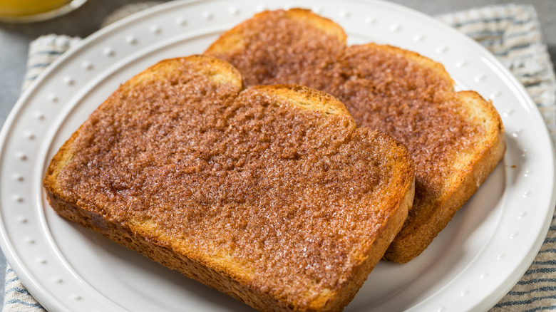 Two slices of cinnamon sugar toast on white plate.