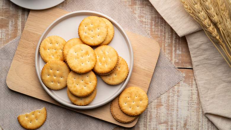 Bird's eye view of peanut butter filled Ritz crackers on white plate on counter.