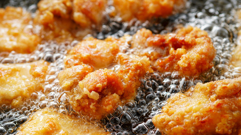 Close-up view of deep-frying chicken on a tray