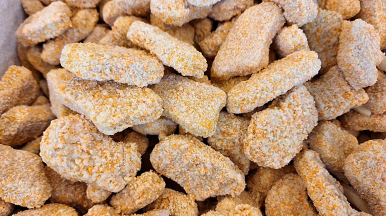 A close-up view of a pile of frozen chicken nuggets in a bag