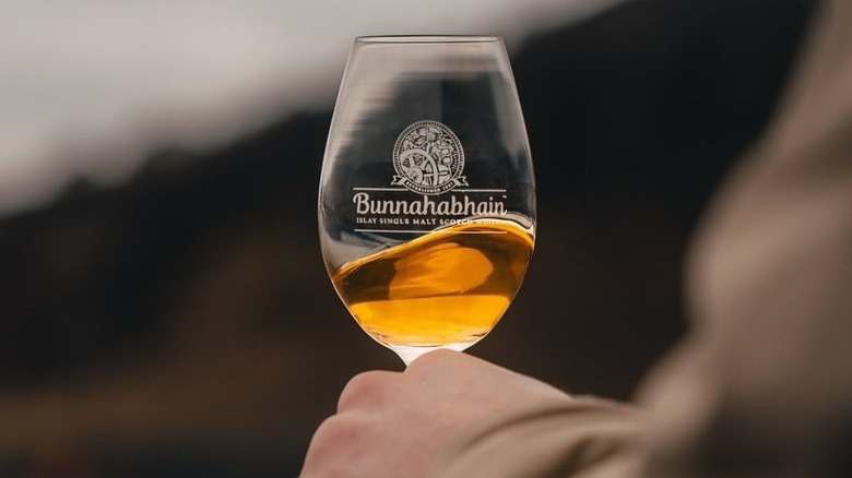 A person holding a glass of Bunnahabhain whisky