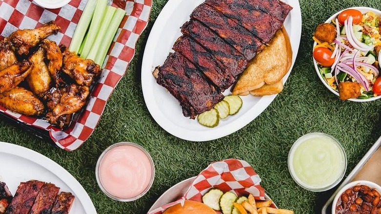 A basket of grilled chicken, a plate of ribs, and a salad from Joe's Kansas City Bar-B-Que