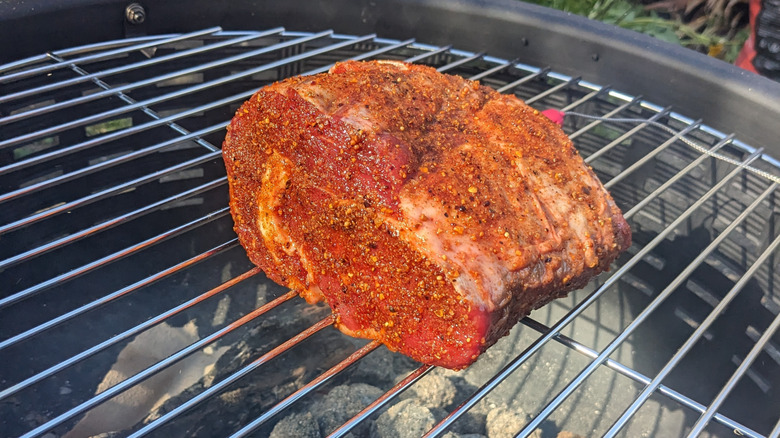 Steak being reverse seared on a charcoal grill