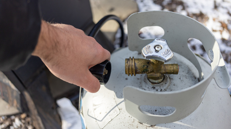 Person attaching propane to a tank