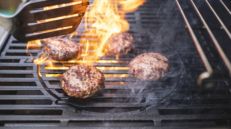 Person grilling burgers on a grill