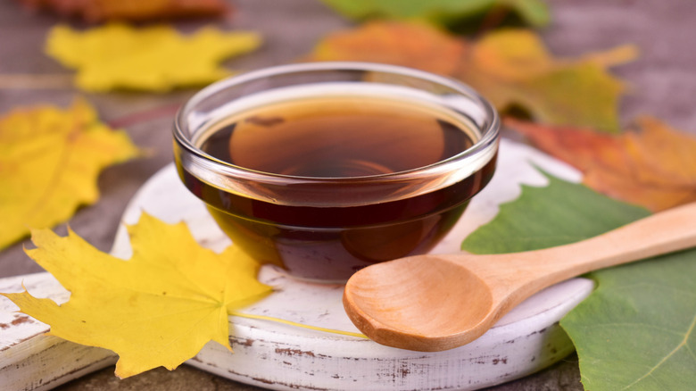 Clear bowl of maple syrup on wooden surface