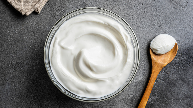 Bowl of sour cream with a wooden spoon