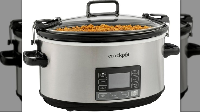 Stainless steel slow cooker with shredded chicken inside
