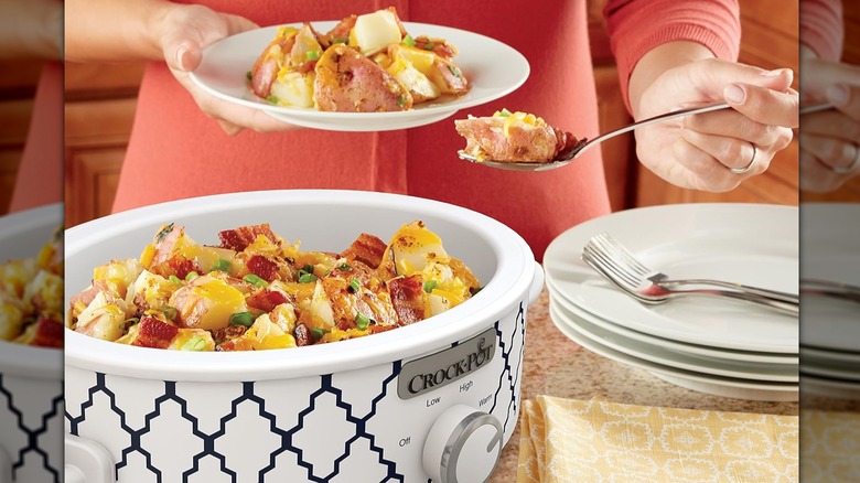Person scooping up a potato dish from a blue and white patterned slow cooker