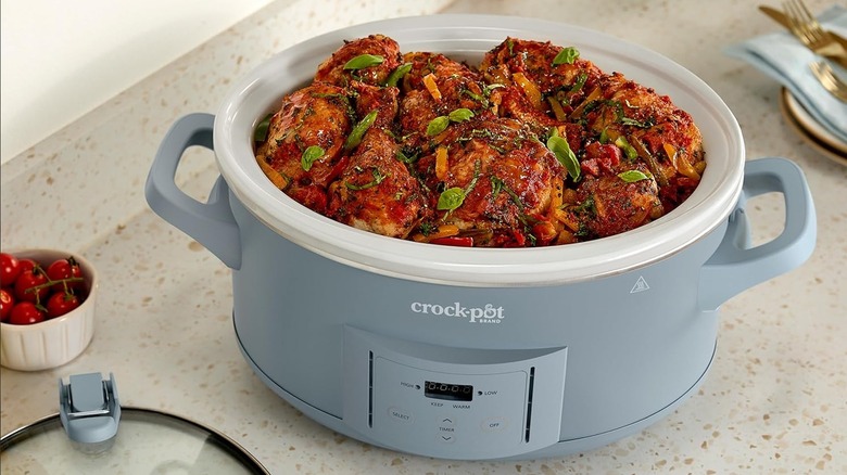Light grey slow cooker opened to show chicken recipe
