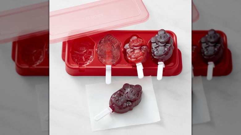 A red Mickey Mouse pop mold with a red lid