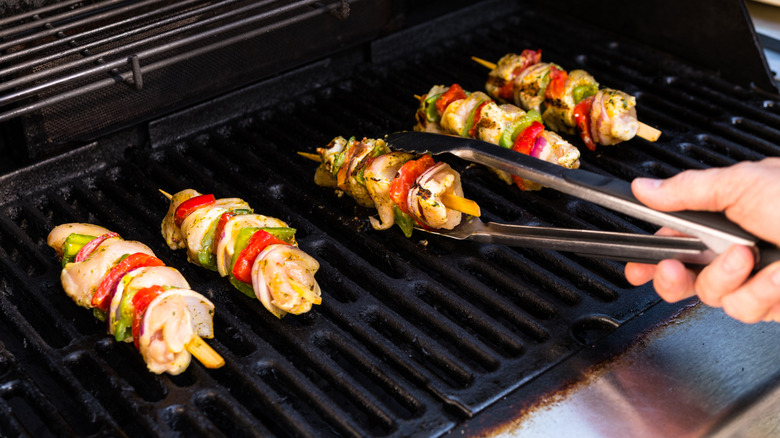 Chicken kebabs with vegetables cook on a grill