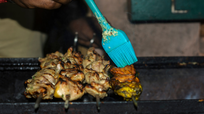 Chicken kebabs are brushed with butter and garlic
