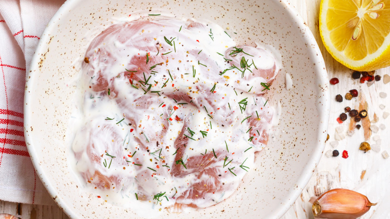 Raw chicken marinates in seasoned yogurt