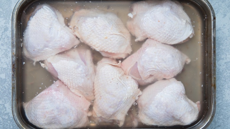 Chicken thighs sit in grind