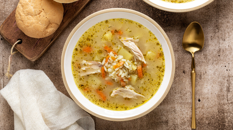 Top view of homemade rice and chicken soup in a bowl