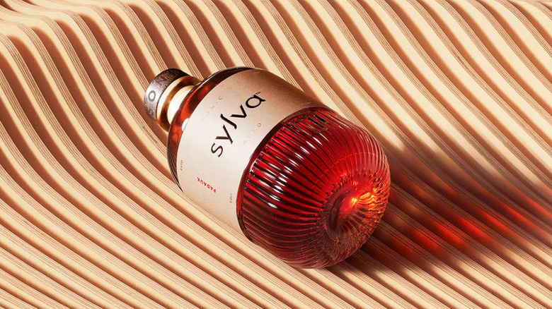 A bottle of Sylva on a wavy wooden background