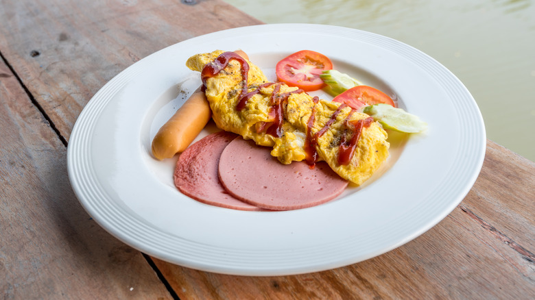 eggs on a plate with bologna and tomatoes