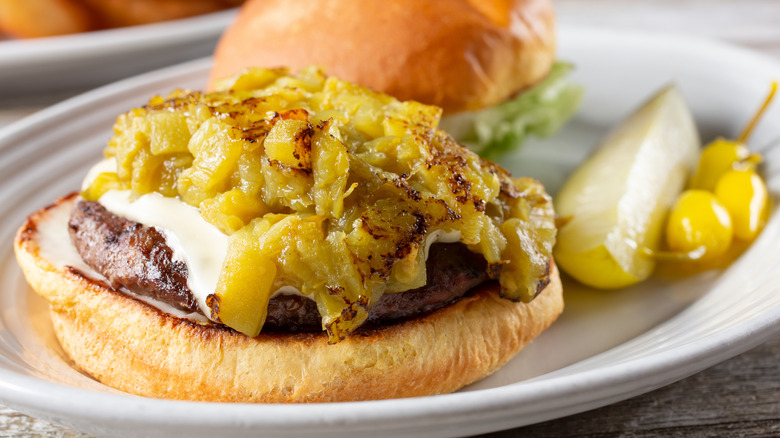 An open-faced burger with green chiles