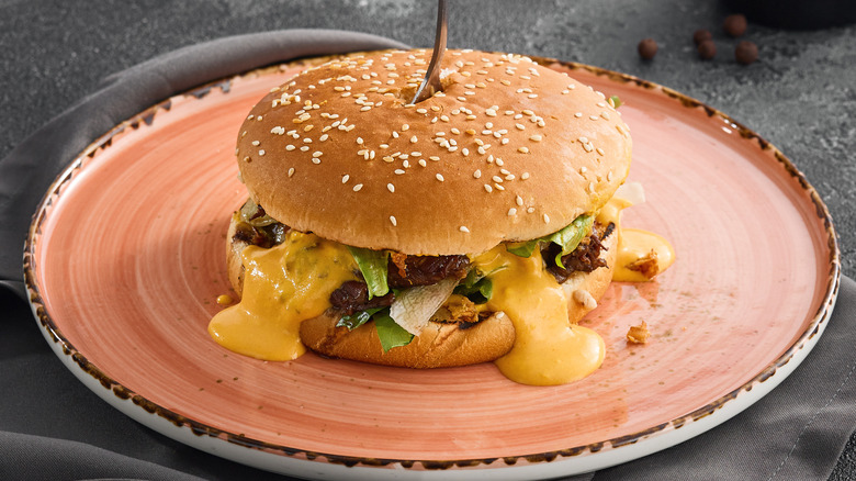 Burger on a plate with cheese sauce