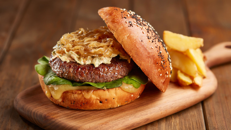 Burger with sauerkraut and onions on a plate