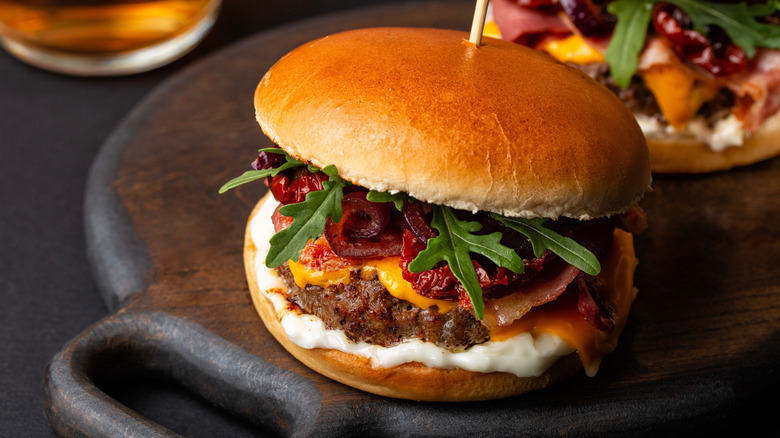 Burger topped with creamy sauce and sun-dried tomatoes