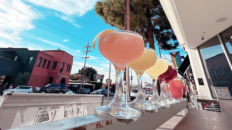 Margaritas balanced on a railing at The Black Cat