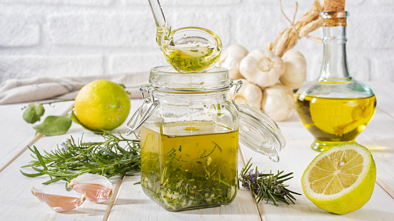 A jar of vinaigrette with lemon and herbs