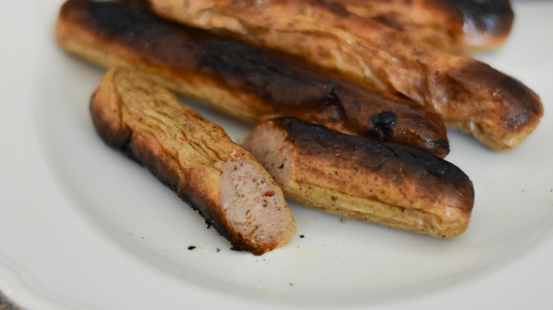 A white plate with cut chicken apple breakfast sausage