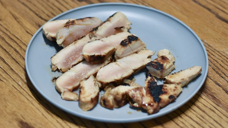 A plate of teriyaki chicken sliced to show the uncooked center