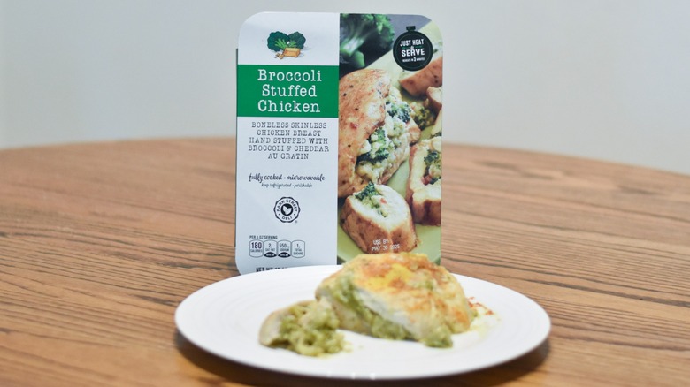 A package of Aldi broccoli stuffed chicken next to a white plate with prepared chicken