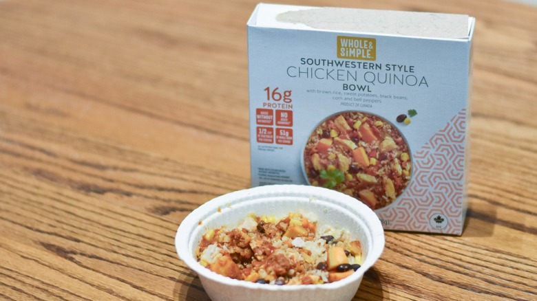 A box of microwavable Southwestern style chicken quinoa bowl next to the prepared bowl