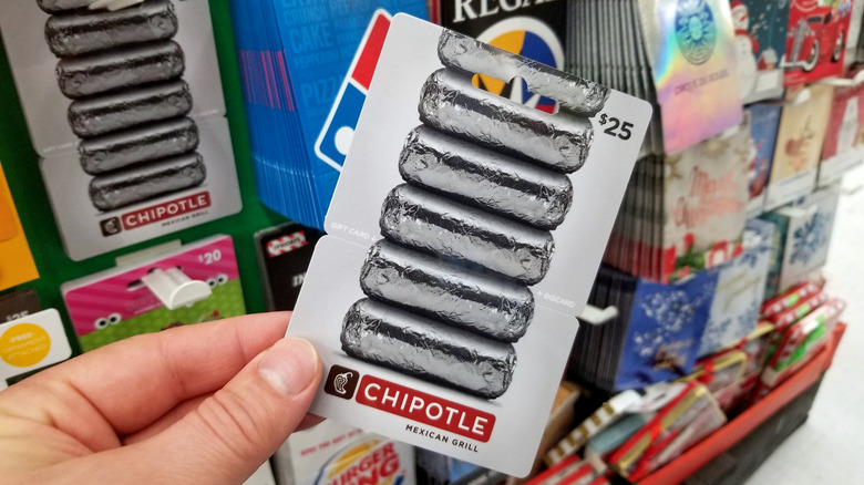 A hand holding a Chipotle gift card