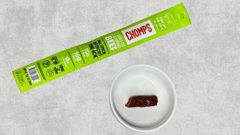 Chomps Chili Lime beef stick on a table next to a sample