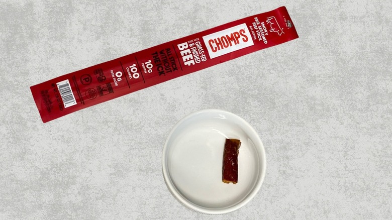 Chomps Smoky BBQ Beef stick next to a sample on a table