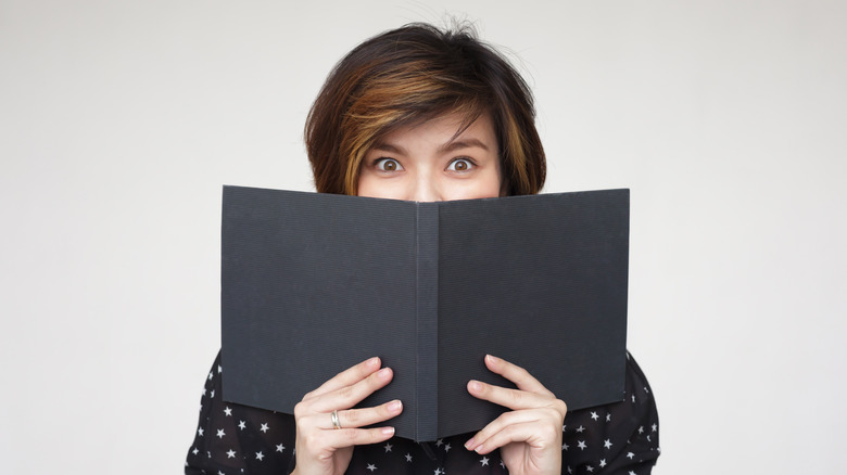 Woman hiding behind a menu