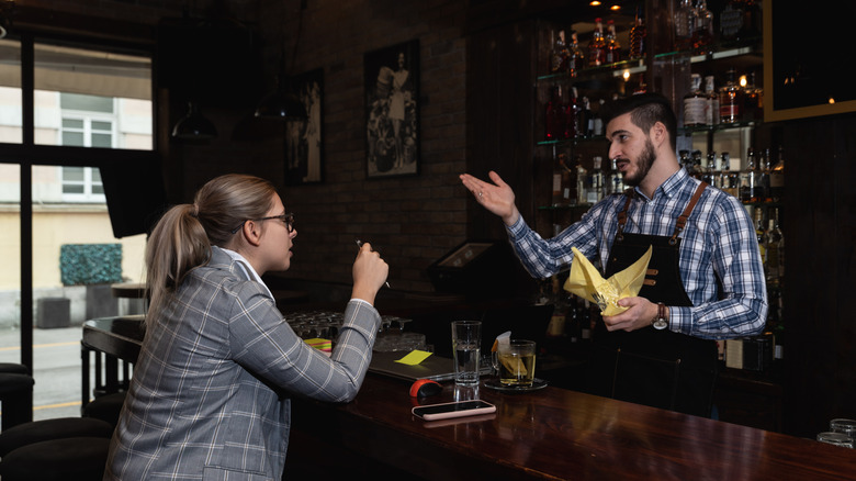 Bartender talking with customer in a bar