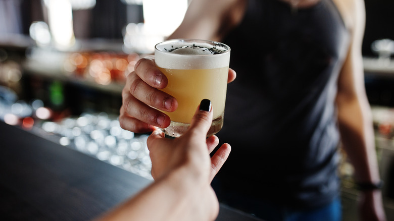 Person handing a drink over to a customer