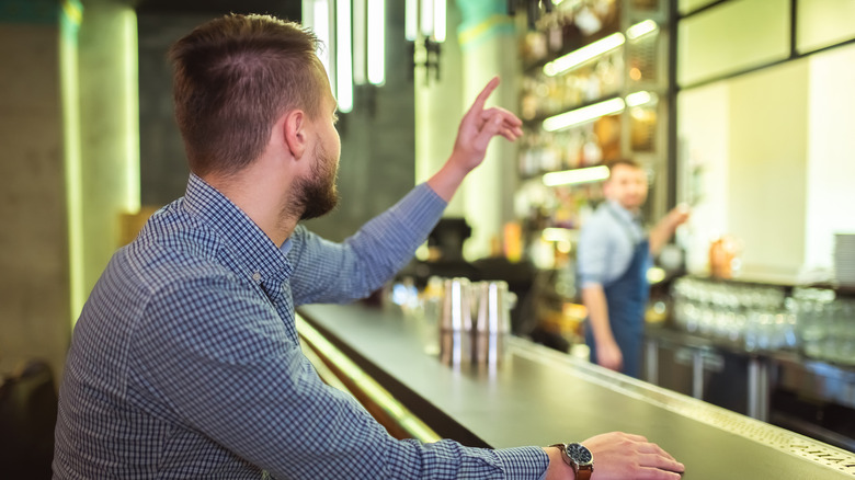 Person getting attention at a bar