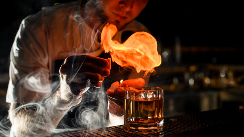 Person smoking a cocktail at a bar
