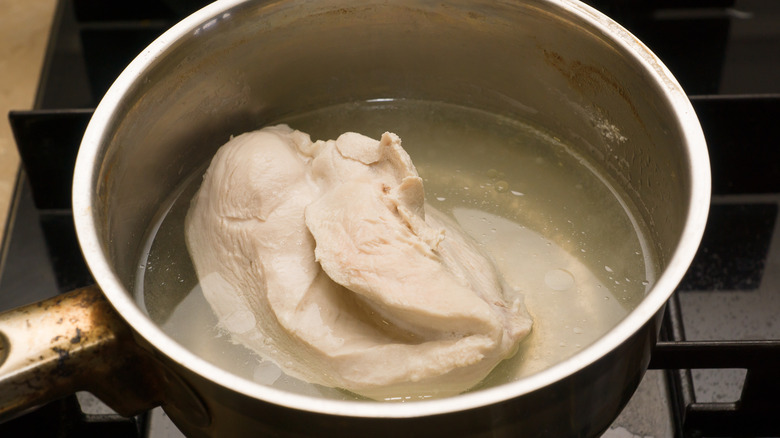 Saucepan of water with a chicken breast inside