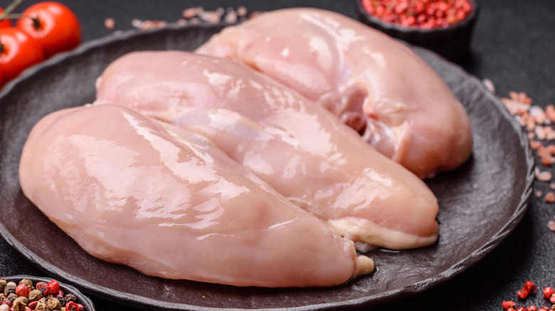 Raw chicken breasts on a plate